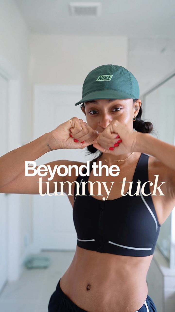 A woman wearing a green Nike cap and a black sports bra is shown from the chest up, with her hands clasped in front of her face. White text overlaid on the image reads "Beyond the tummy tuck." The woman appears to be in a bathroom, with a mirror and a scale visible in the background. The overall impression is one of post-surgery recovery and ongoing self-care.