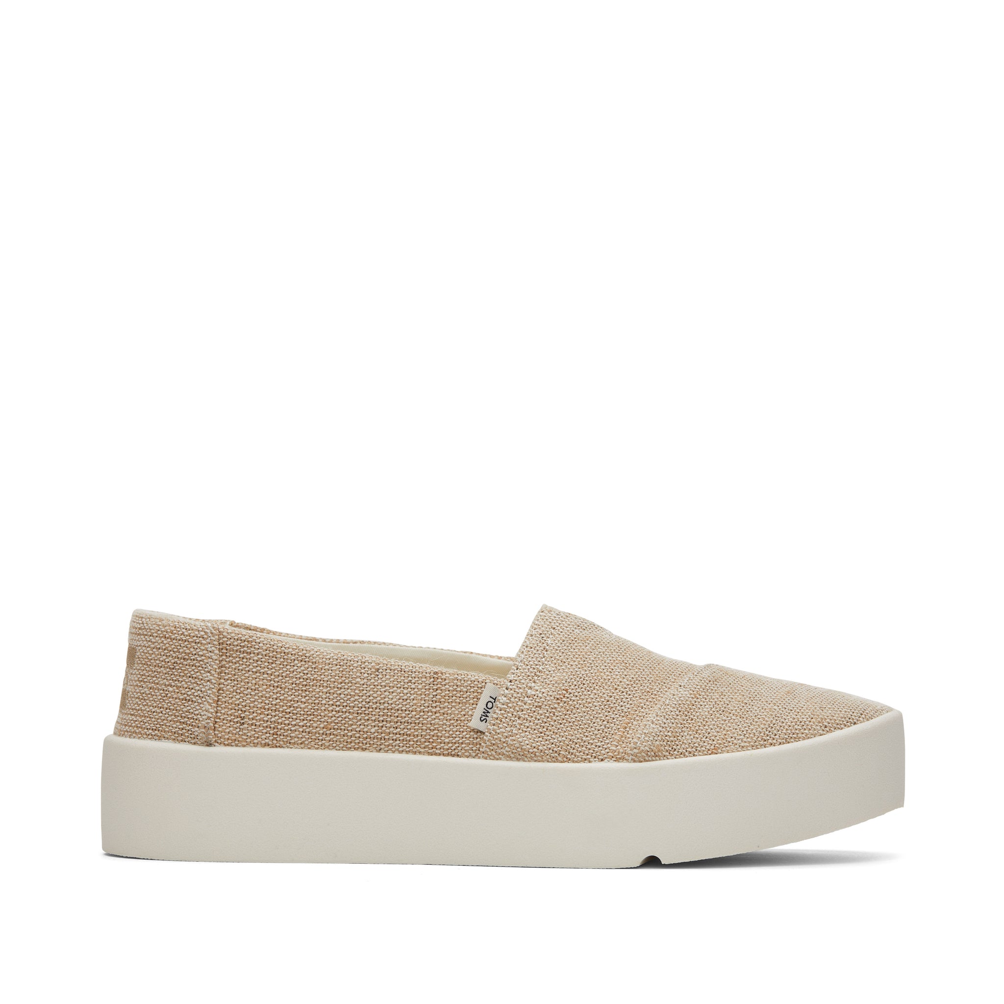 A product shot of a single beige TOMS slip-on shoe with a thick white platform sole. The shoe is shown from the side against a plain white background. The TOMS logo is visible on a small tag on the side of the shoe. The text "Get these TOMS bestsellers before they're gone!" is overlaid on the image in a simple, sans-serif font.