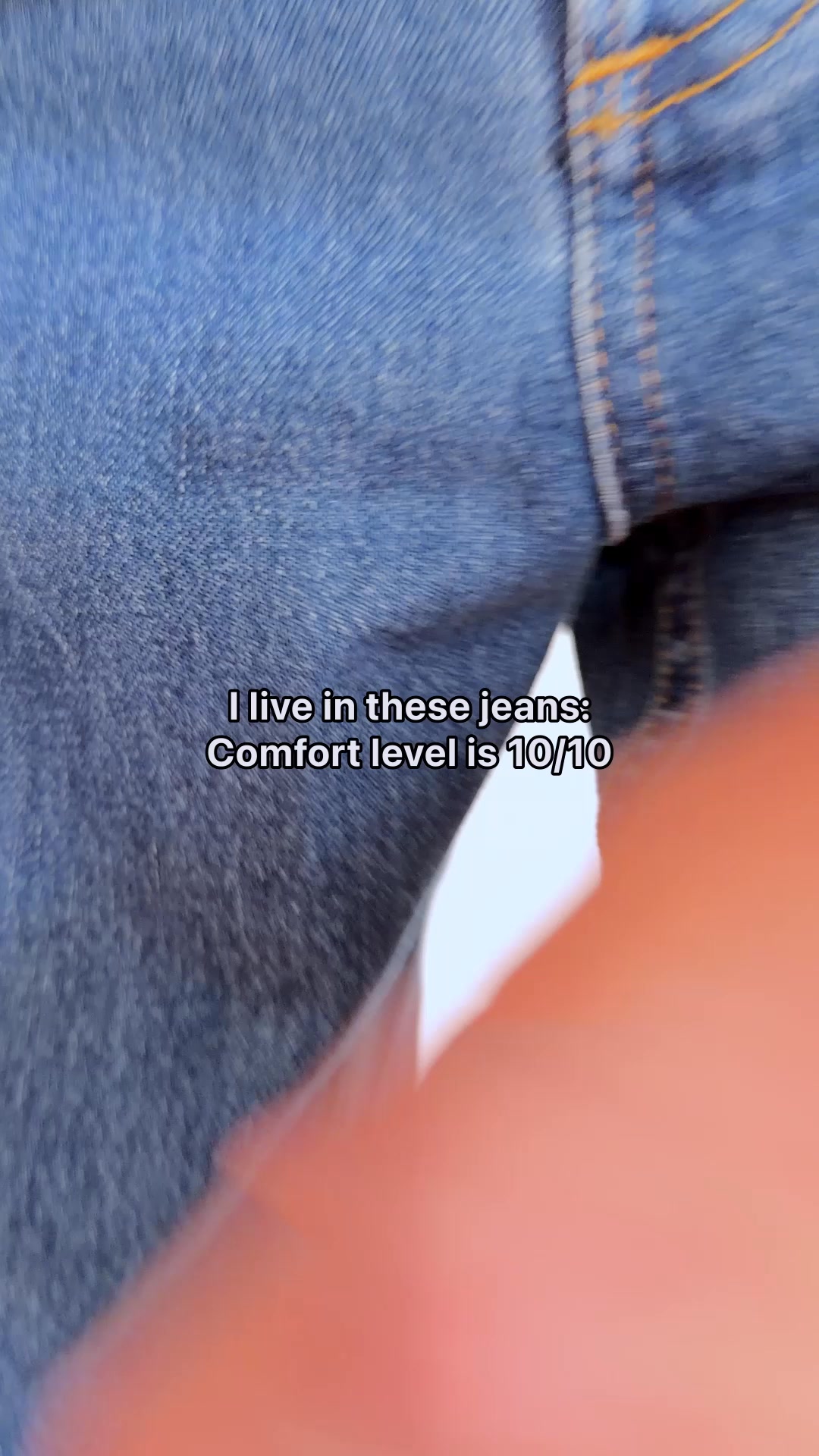 A close-up shot of blue denim jeans. White text overlaid on the image reads "I live in these jeans: Comfort level is 10/10". The text suggests the wearer finds the jeans extremely comfortable and wears them frequently.