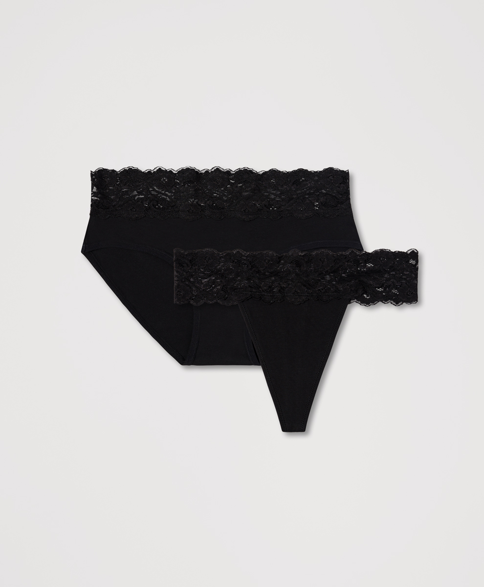 A studio shot of two black lace-trimmed underwear items against a plain white background. One is a high-waisted brief, and the other is a thong. The copy is overlaid on the image, describing the items as "beautifully simple essentials designed with softness, ease, and intention."