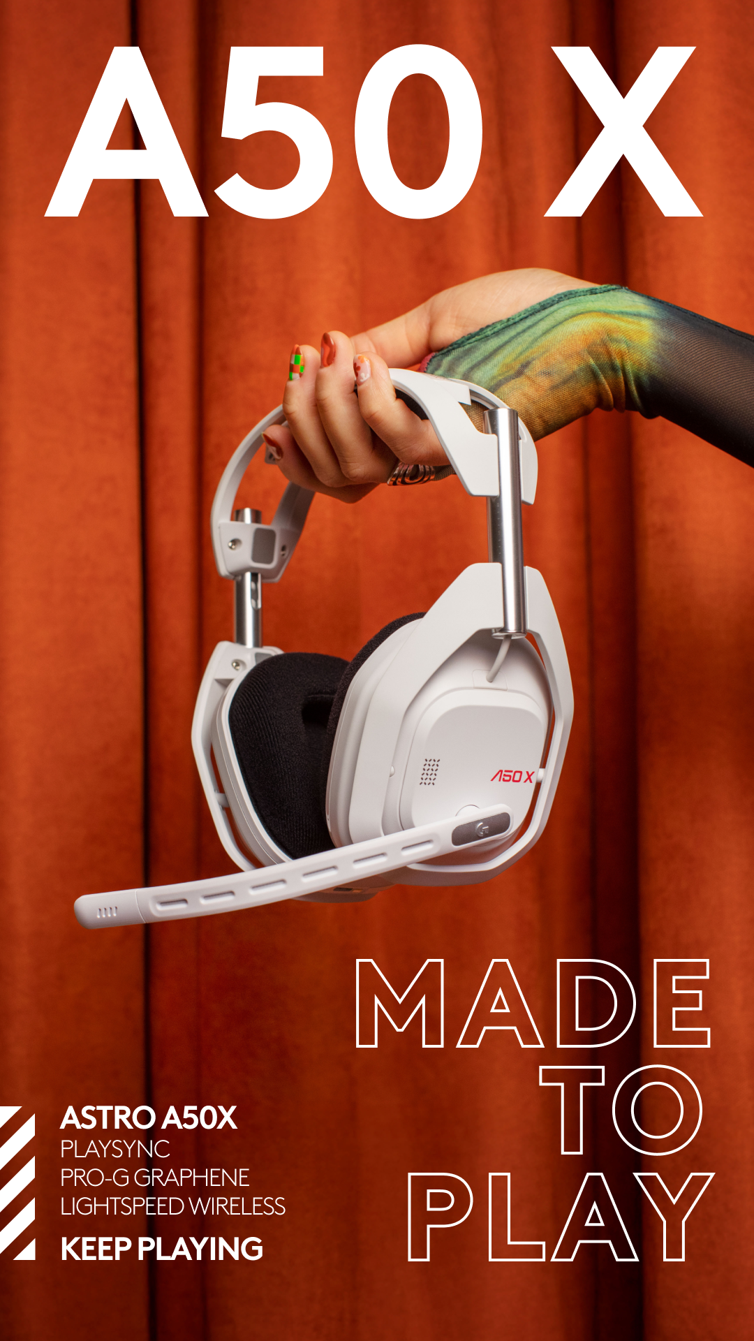 A white ASTRO A50 X headset is held up against a rust-colored curtain backdrop. The headset has a microphone boom extending from the left earcup. Large white text on the upper portion of the image reads "A50 X". Below the headset, on the left, is white text listing "ASTRO A50X", "PLAYSINC", "PRO-G GRAPHENE", "LIGHTSPEED WIRELESS", and "KEEP PLAYING". On the right side of the image, large white outlined text reads "MADE TO PLAY".